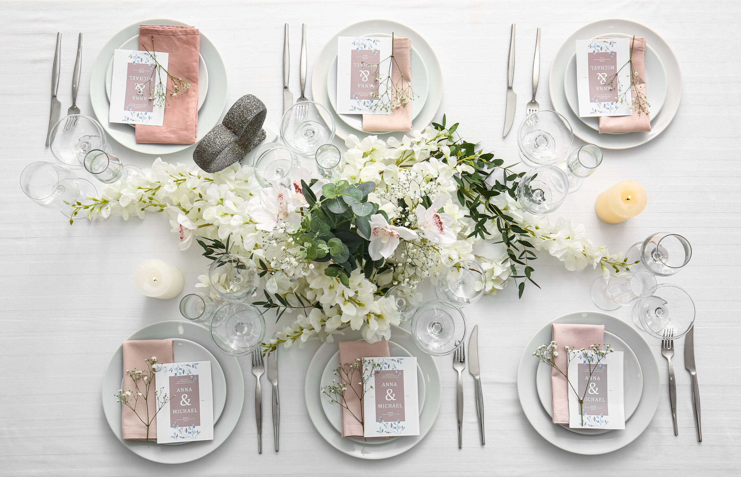 Stylish table setting with wedding invitations and gypsophila flowers, top view